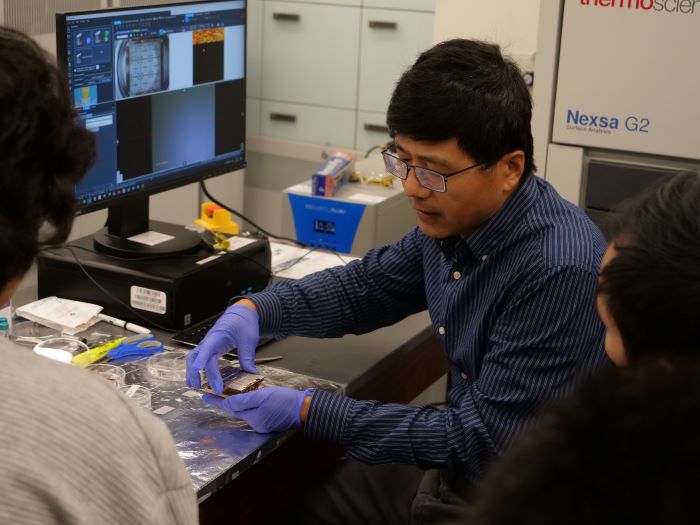 Dr. Xinqi Chen inserts live sample