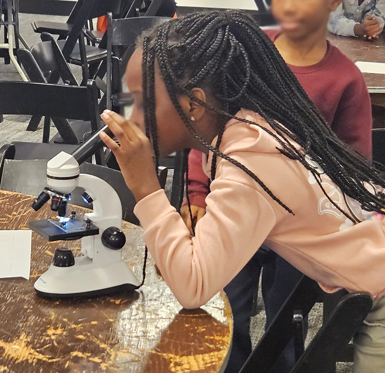 Student looking into Microscope